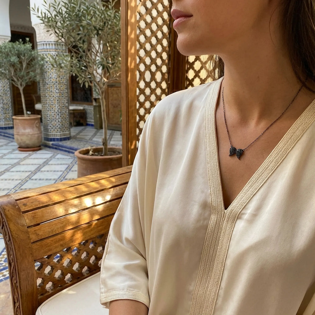 Elegant woman in a luxurious setting naturally wearing our premium women's black jewelry to highlight sophisticated everyday style.