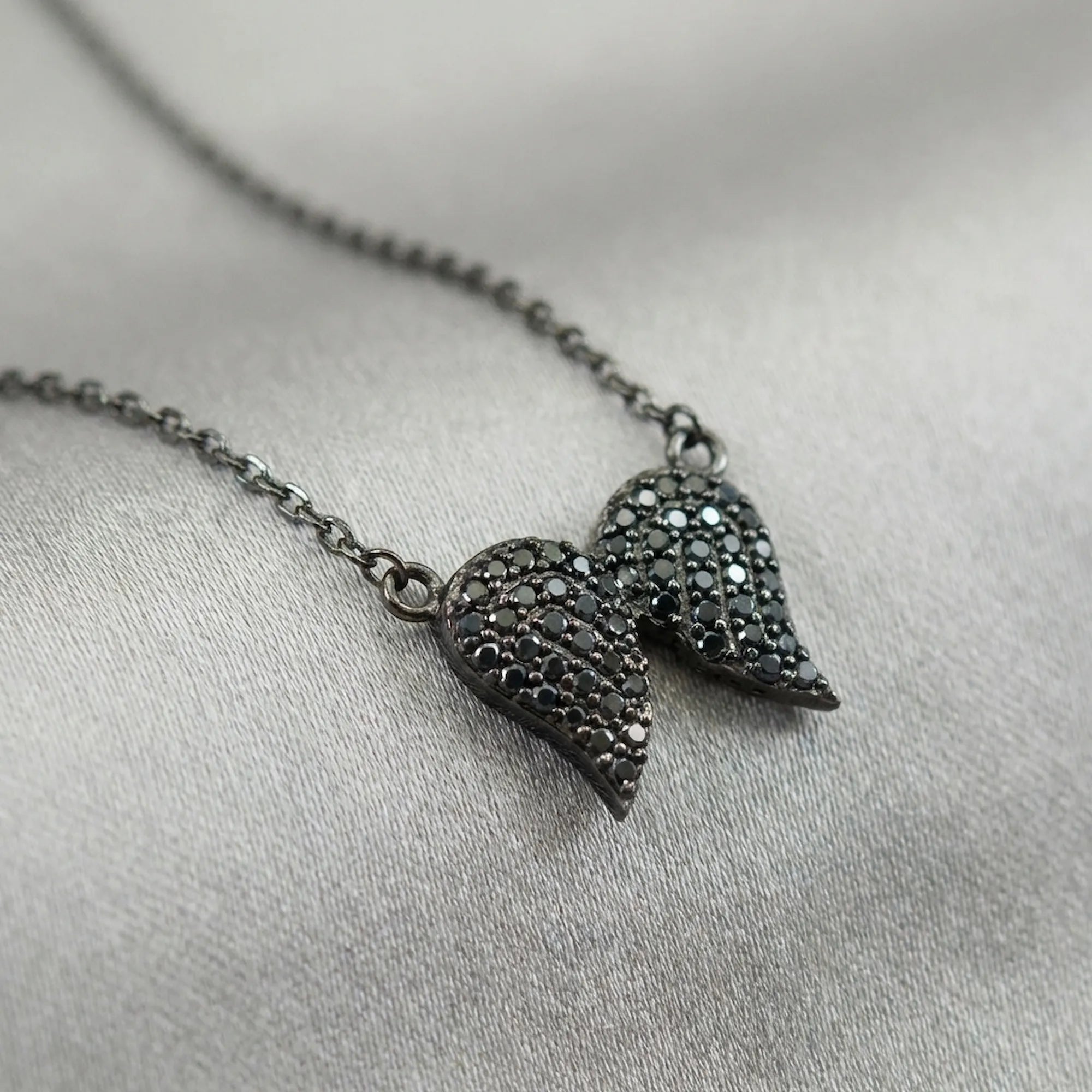 Close-up macro detail shot of the black zircon gemstones precisely set in the women's black jewelry sterling silver pendant.