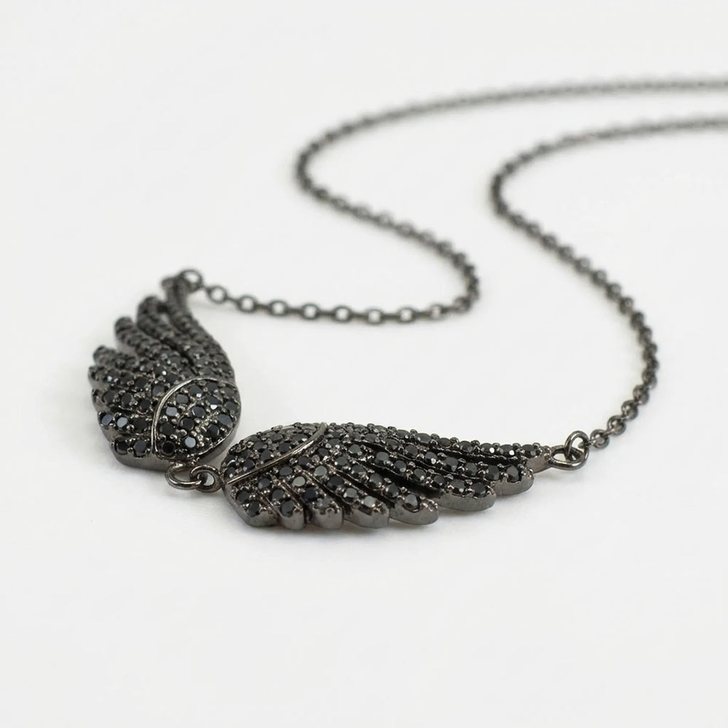 Side-angle view of the Black Zircon Wing Necklace showing the dimensional feather detail and black stones.