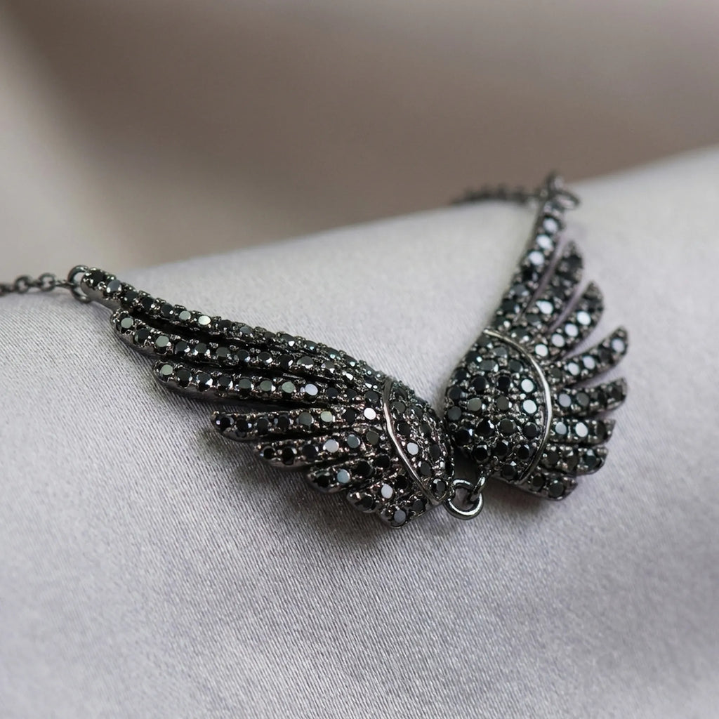 Close-up macro shot of the black zircon gemstones on the sterling silver wing necklace.