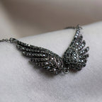 Close-up macro shot of the black zircon gemstones on the sterling silver wing necklace.