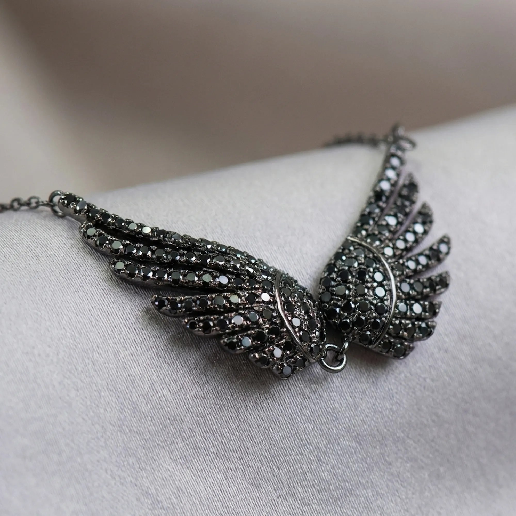 Close-up macro shot of the black zircon gemstones on the sterling silver wing necklace.