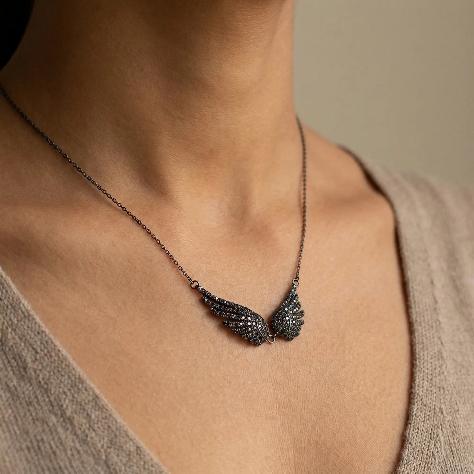 A model wearing the Black Zircon Wing Necklace to show the 40cm scale and fit on the neckline.