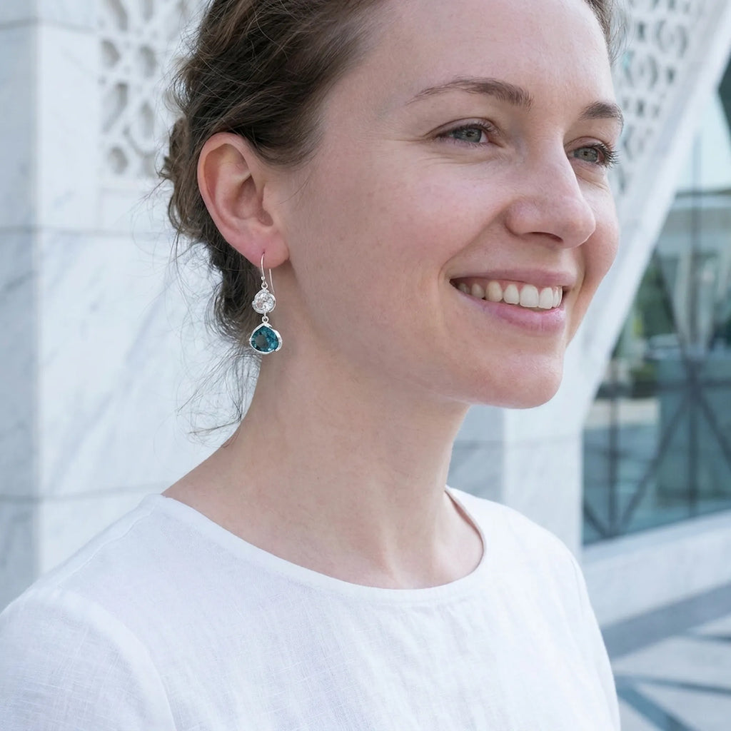 Woman wearing blue topaz lotus silver earrings, Mashrabiya screen backdrop, Wafi City Dubai.