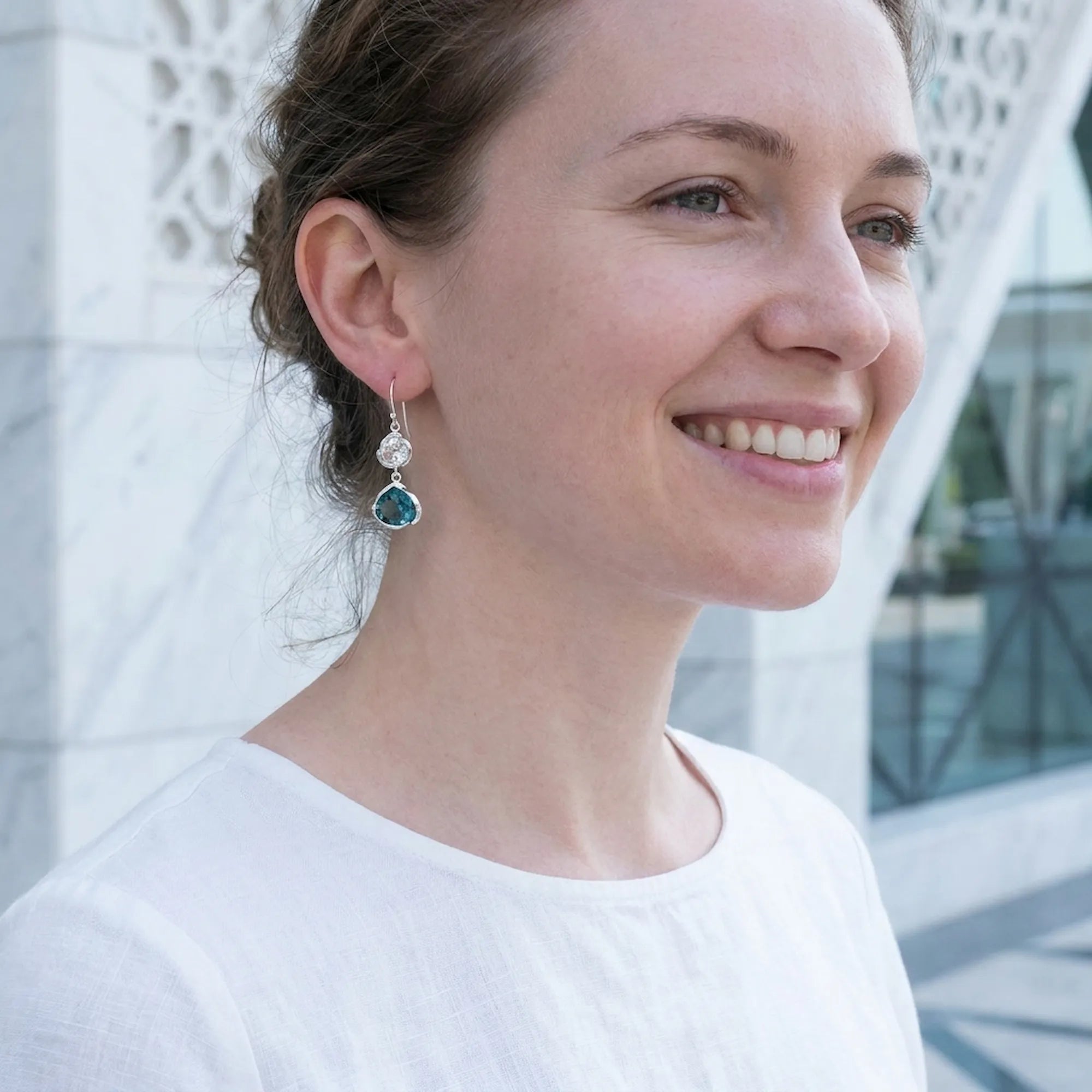 Woman wearing blue topaz lotus silver earrings, Mashrabiya screen backdrop, Wafi City Dubai.