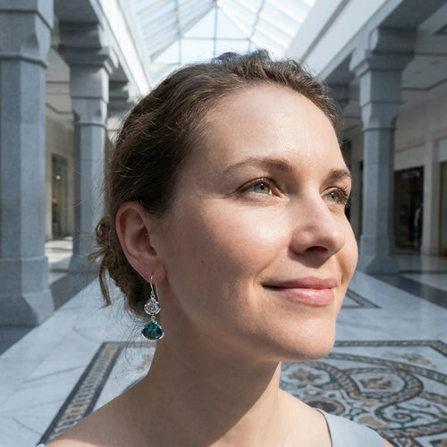 Side profile of a woman showcasing the blue lotus silver dangle earrings inside Wafi City mall in Dubai.