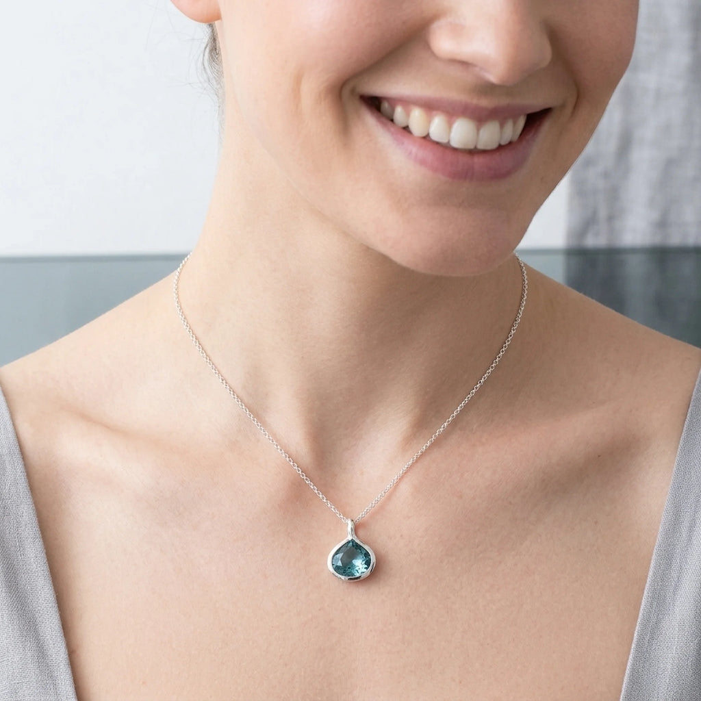 Smiling woman wearing a natural Sky Blue Topaz 925 silver lotus necklace in Dubai.