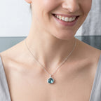 Smiling woman wearing a natural Sky Blue Topaz 925 silver lotus necklace in Dubai.