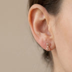 Side profile of model wearing rose gold shabaka bow stud earring, taupe wall background Luna Dura Studio