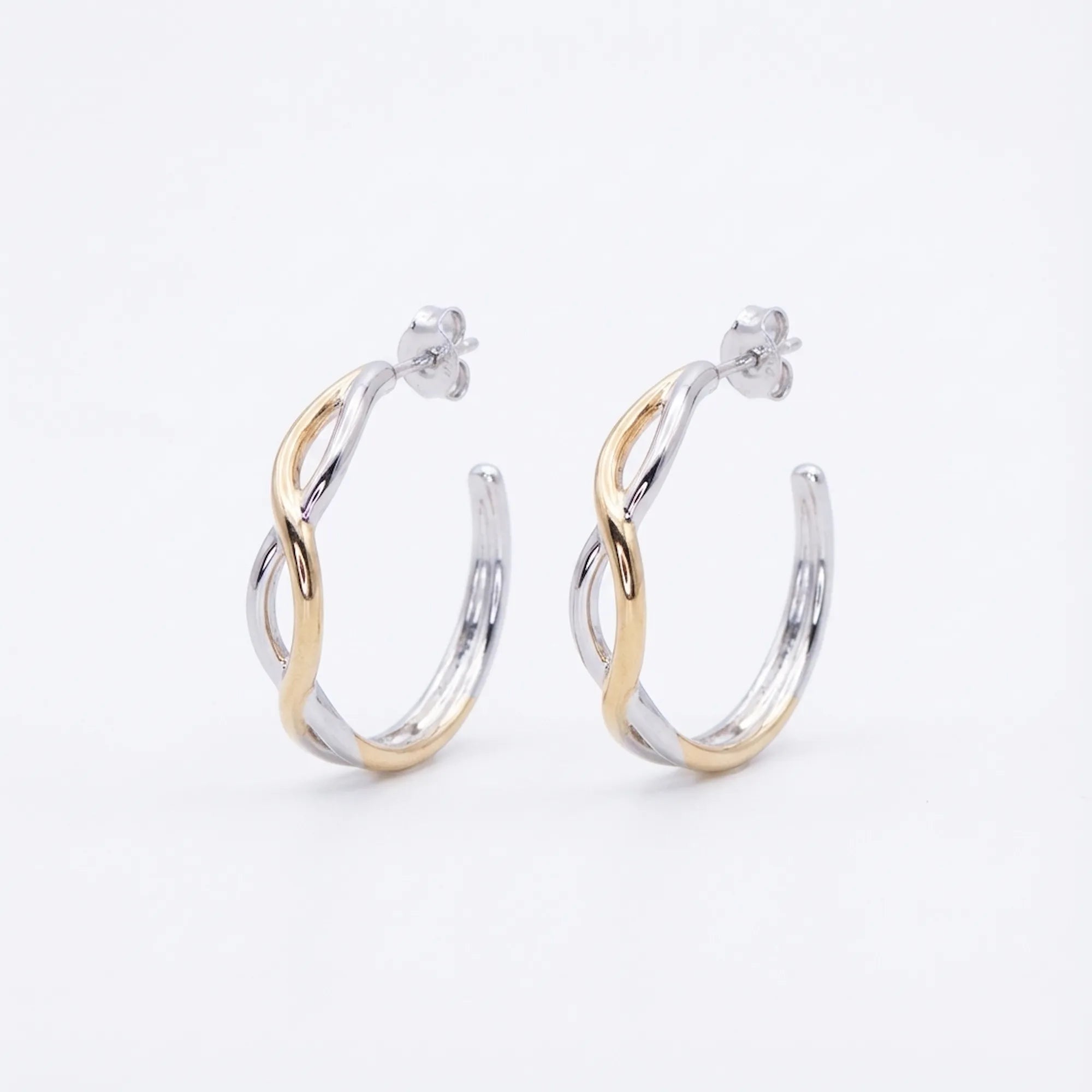 Two-tone silver and gold bypass hoop earrings on white background — interlaced wave design, post-back, 925 sterling silver.