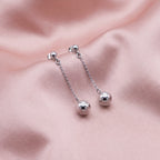 925 sterling silver chain drop earrings with 6mm polished spheres displayed on pink fabric in Dubai.