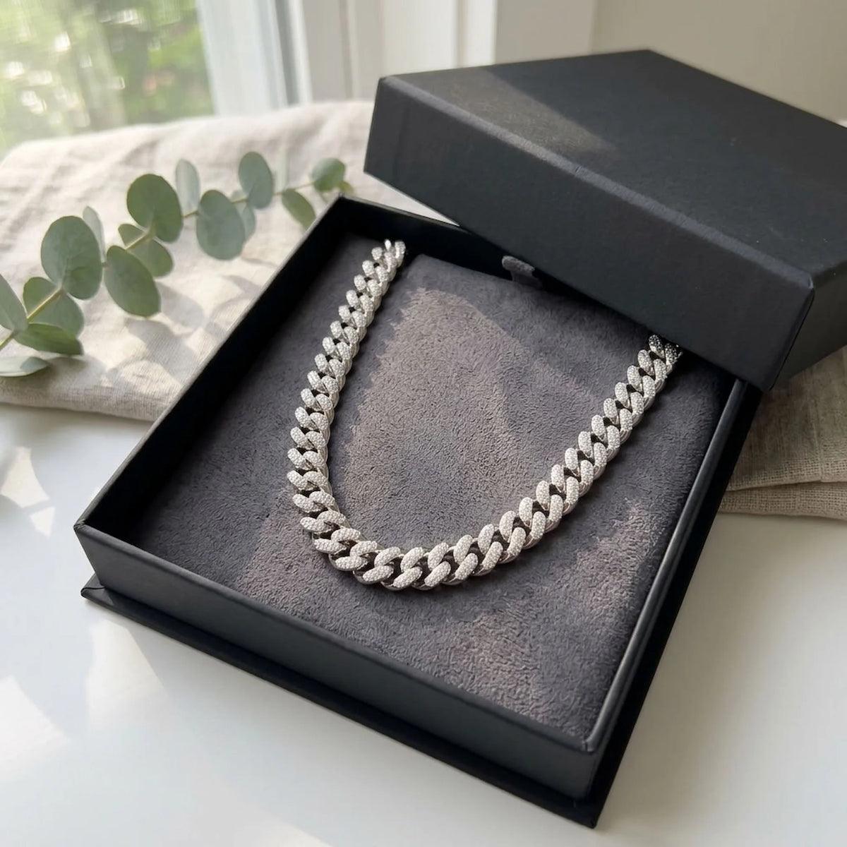 Chunky rhodium-plated copper pave Cuban necklace displayed inside a black gift box in Dubai.