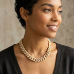 Chunky 18k gold-plated copper pave Cuban necklace with cubic zirconia worn by a woman outdoors in Dubai.