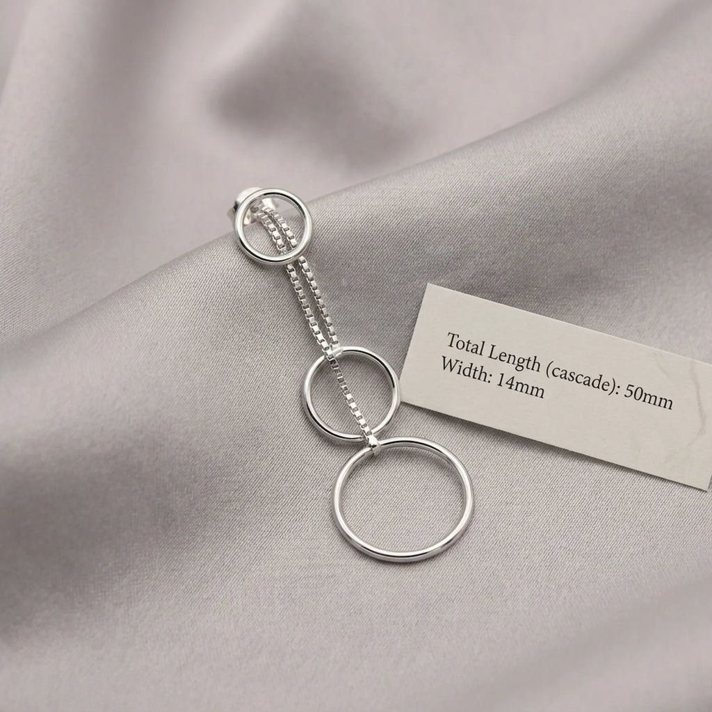 Silver circle cascade drop earring on grey fabric beside spec card showing 50mm total length and 14mm width