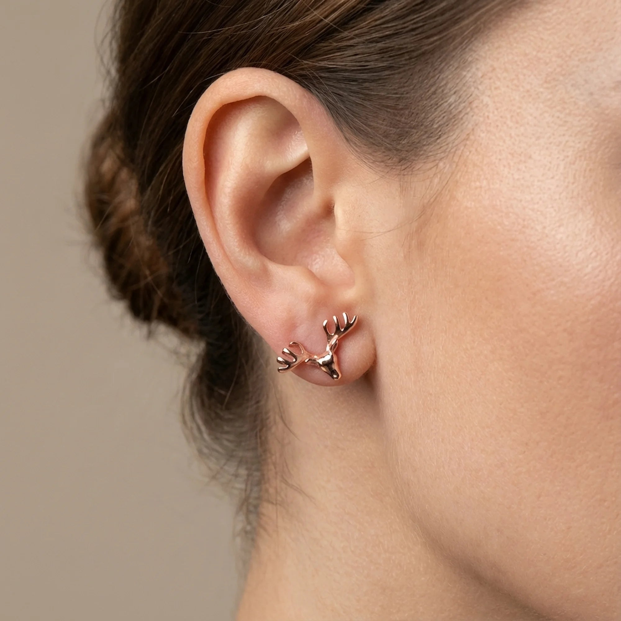 18K rose gold plated 925 sterling silver antler stud earrings worn by a smiling woman in Dubai.