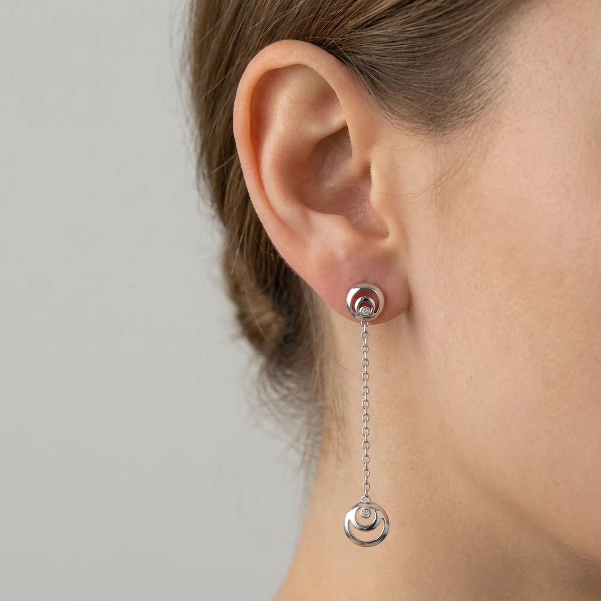 Rhodium silver crescent moon drop earring worn on ear — 925 sterling silver, 50mm chain drop, bezel CZ