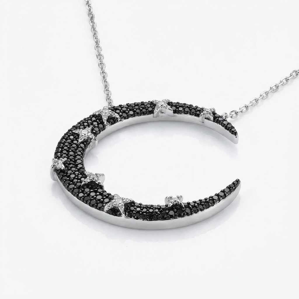 Angled view of 925 silver crescent moon pendant — full black zircon pavé with white CZ star detailing, neutral background