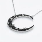 Angled view of 925 silver crescent moon pendant — full black zircon pavé with white CZ star detailing, neutral background