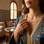 Crescent moon necklace worn with embroidered blue kaftan in Arabic interior setting — celestial silver pendant Dubai