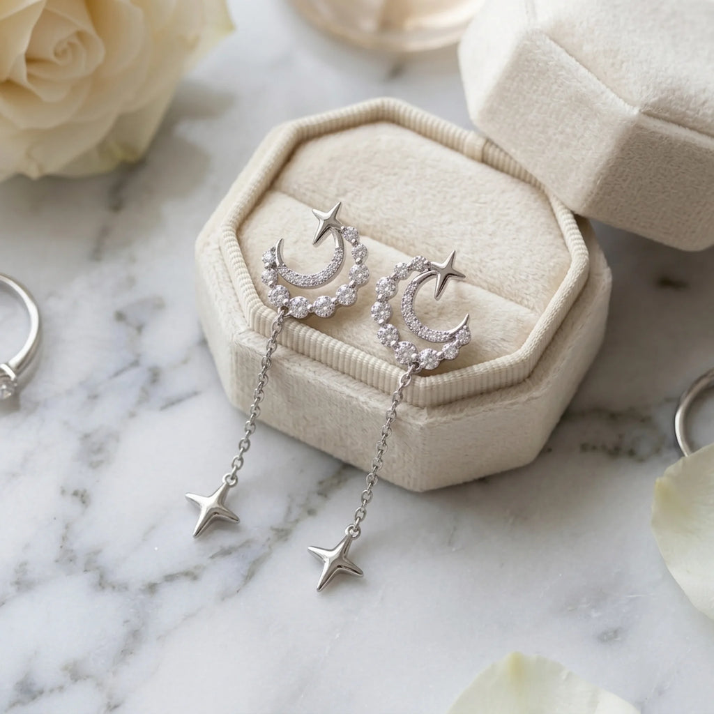 Rhodium silver crescent moon and star drop earrings with cubic zirconia in a velvet box, available in Dubai.