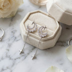 Rhodium silver crescent moon and star drop earrings with cubic zirconia in a velvet box, available in Dubai.