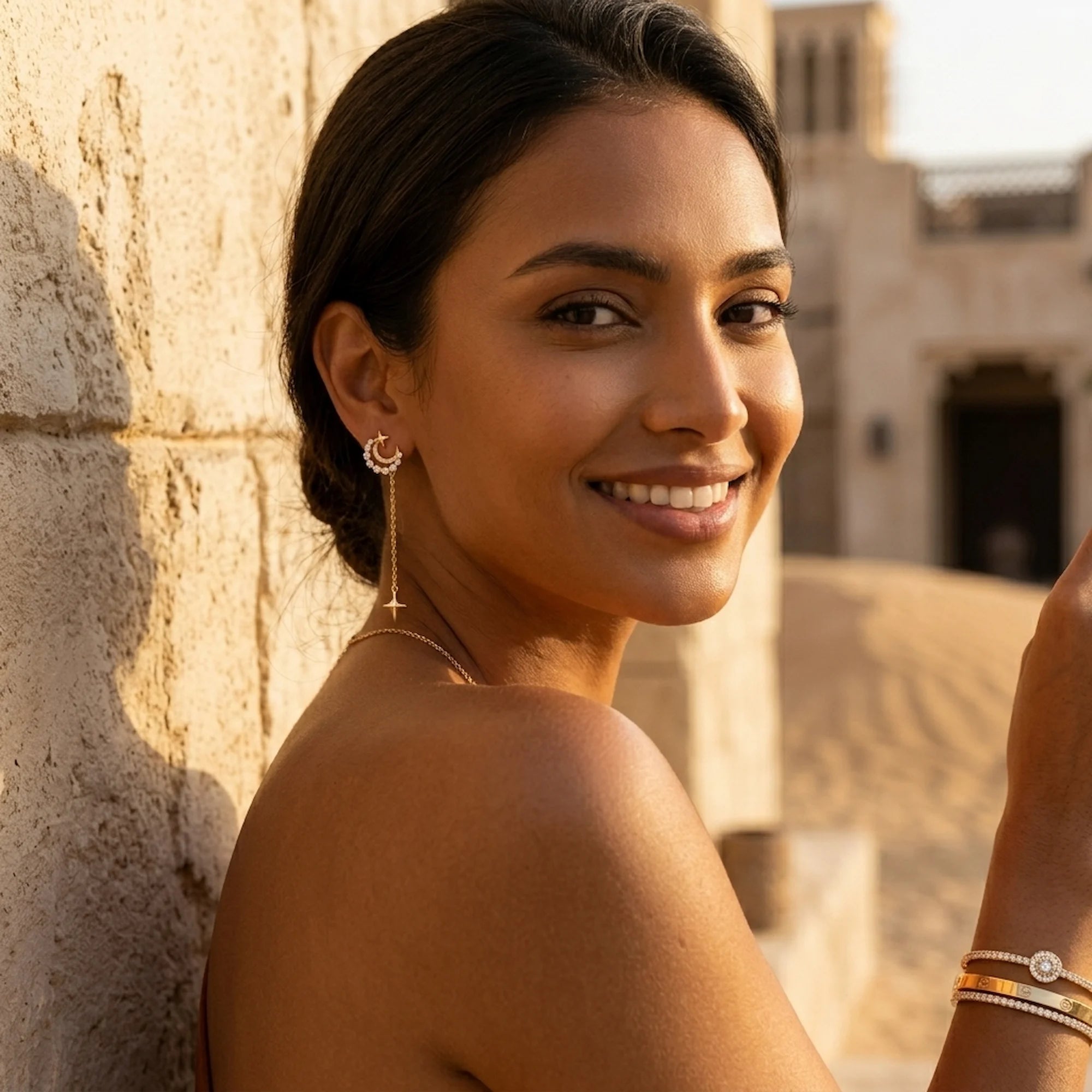 Woman wearing 18K gold plated silver crescent moon star drop earrings at Al Seef waterfront promenade in Dubai.