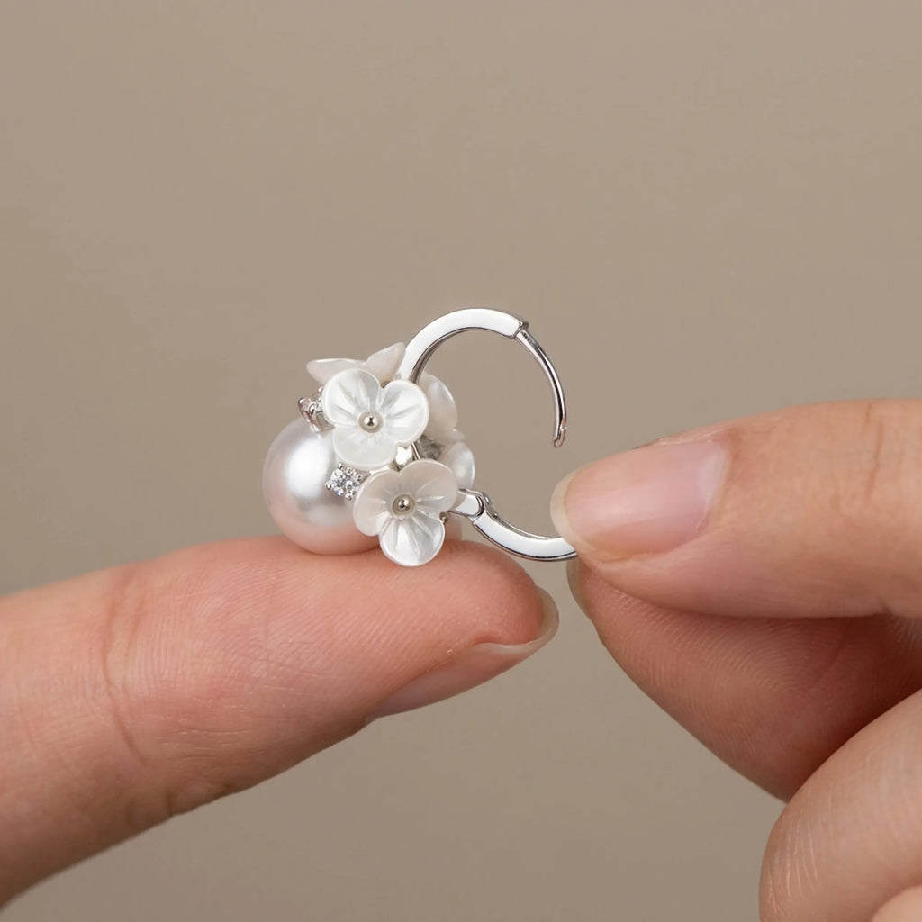 Easily open the secure tension clasp of these cubic zirconia huggie earrings crafted from 925 silver and bright pearl.