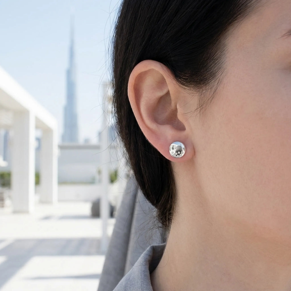 Dome silver stud earring worn on ear with Burj Khalifa in background — 9mm 925 sterling silver, flush CZ, Dubai