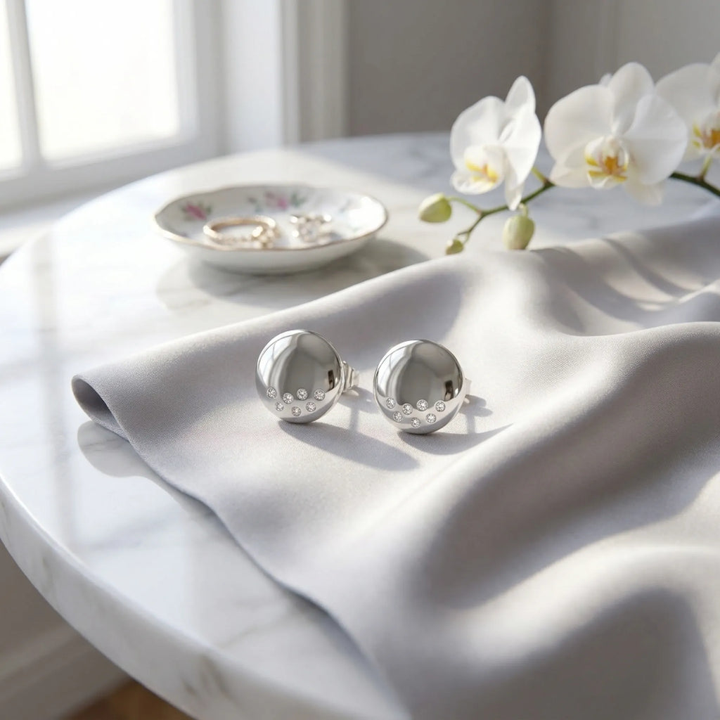 Polished silver dome stud earrings on grey satin fabric with white orchid — 925 sterling silver styled detail