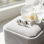 Silver dome stud earrings on grey velvet gift box with white orchid flower — gifting presentation