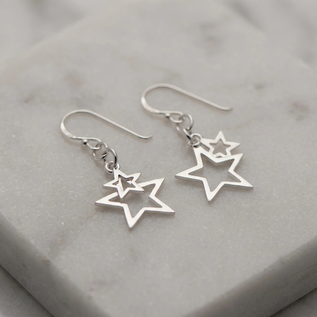 Nested double star drop earrings in 925 sterling silver with pure-silver plate resting on marble, available in Dubai.