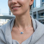 Woman wearing contemporary protective talisman jewelry outdoors featuring 925 silver and blue enamel in dubai.