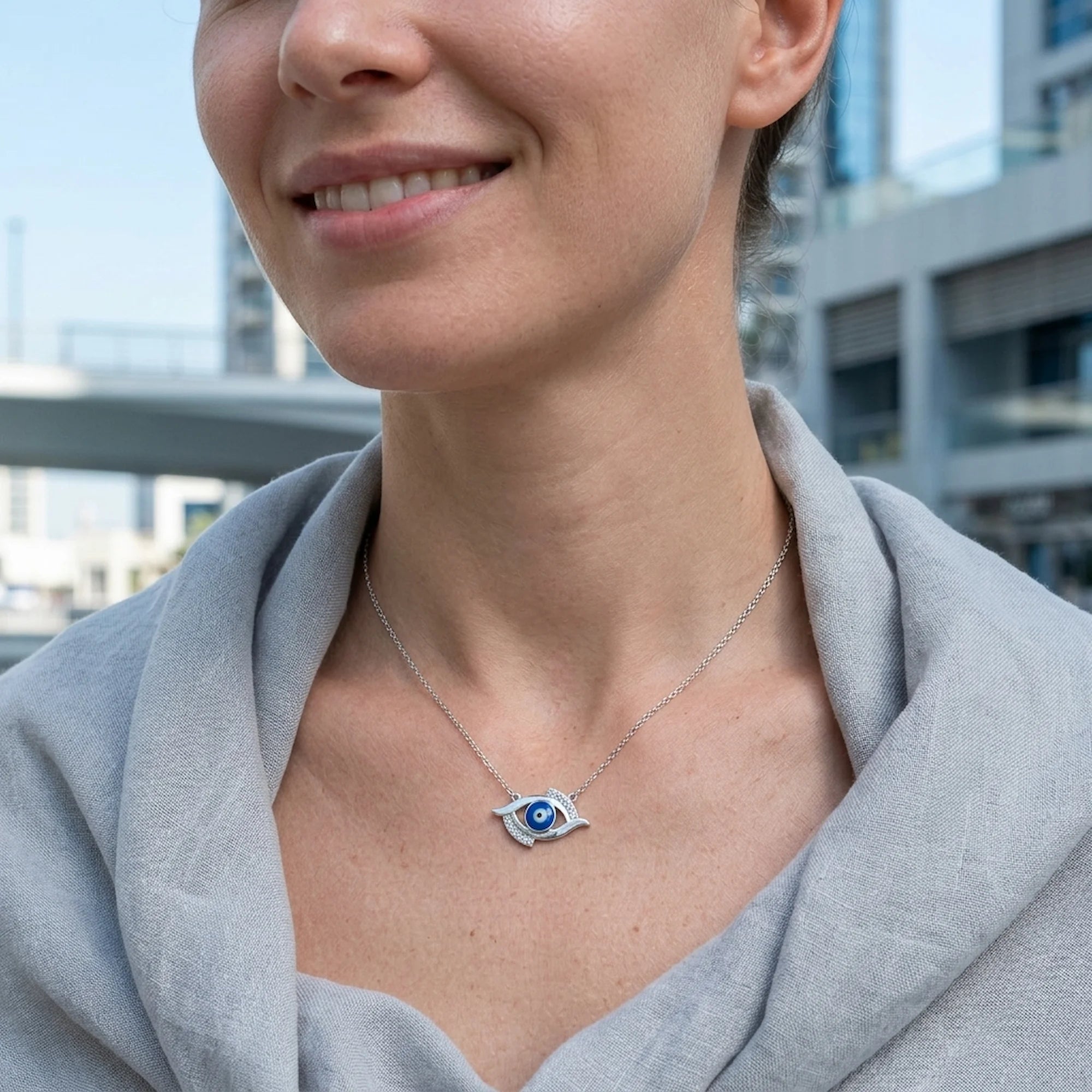 Woman wearing contemporary protective talisman jewelry outdoors featuring 925 silver and blue enamel in dubai.