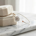 White dual opal evil eye cuff bangle on cream jewellery box, white marble, warm studio lighting