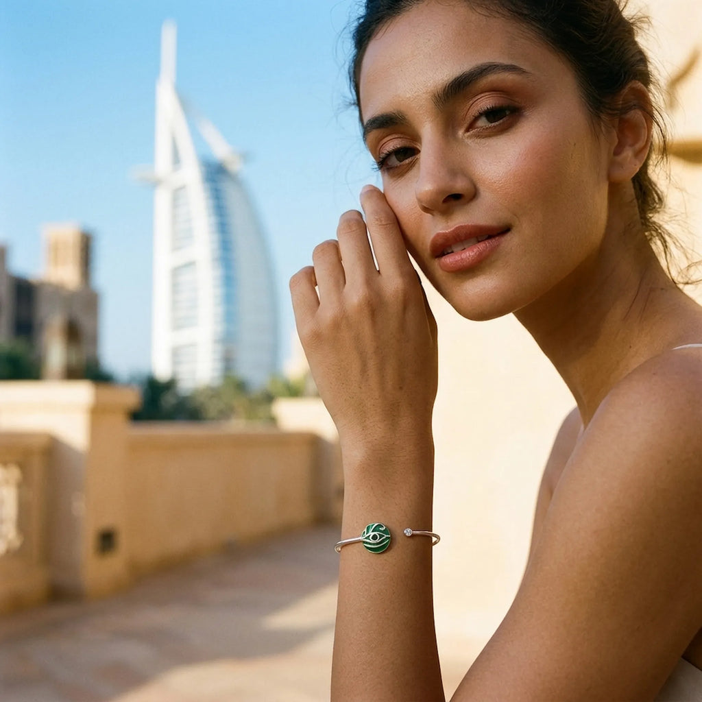 Woman wearing green peridot evil eye cuff bangle near Burj Al Arab hotel, Dubai, Luna Dura