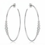 Pair of 70 mm rhodium-finished 925 silver hoop earrings with graduated bezel cubic zirconia. Luna Dura.