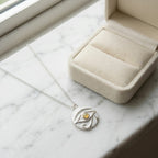 Eye of Horus pendant with natural fire opal in open jewellery box on marble surface, Dubai