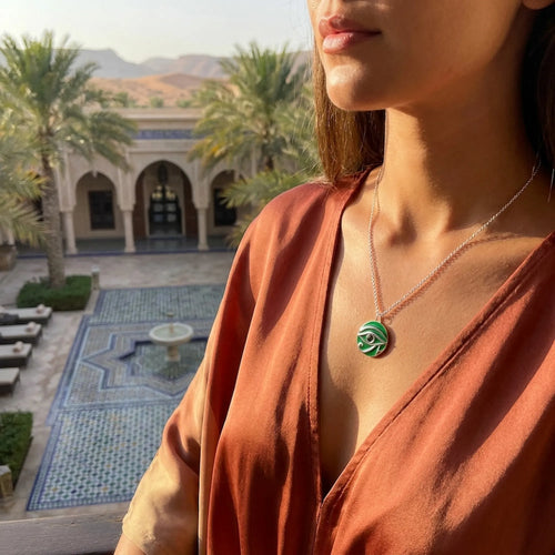 Woman wearing Eye of Horus green enamel peridot pendant at Bab Al Shams Desert Resort Dubai