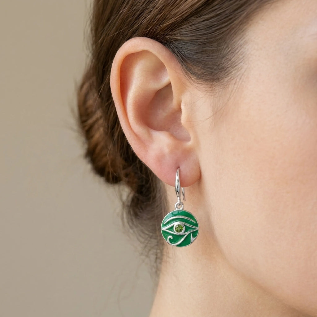 Silver French hook drop earring with green eye motif worn on model