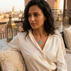 Woman wearing Eye of Horus azure topaz necklace at Bab Al Shams desert resort, Dubai
