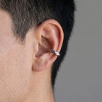 Man wearing a faceted 925 silver ear cuff with no piercing on the cartilage. Luna Dura Dubai.