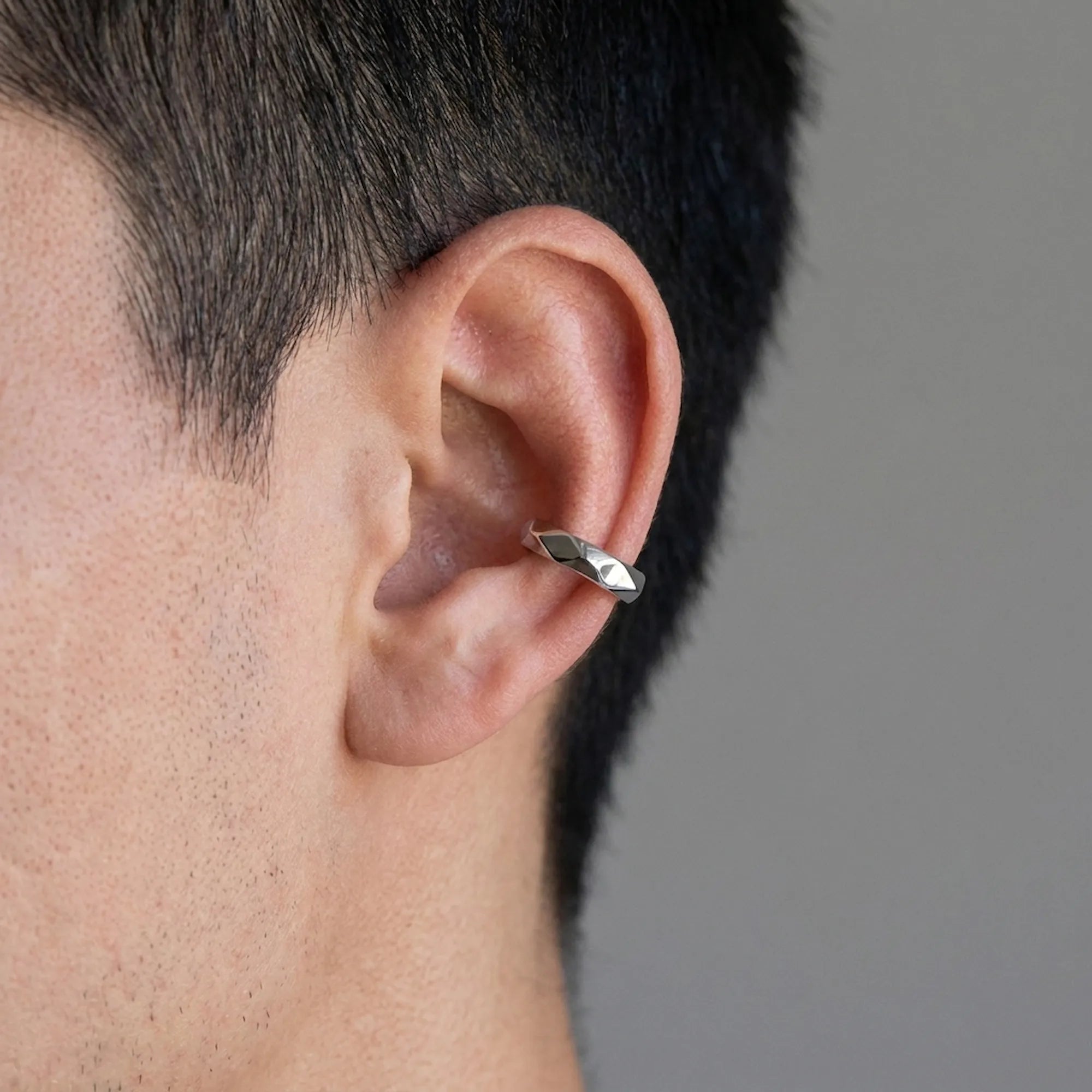 Man wearing a faceted 925 silver ear cuff with no piercing on the cartilage. Luna Dura Dubai.