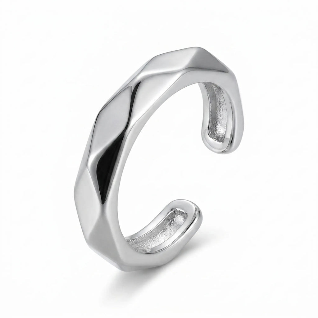 Rhodium 925 silver faceted band ear cuff for non-pierced wear, beside a velvet box on marble. Luna Dura Dubai.