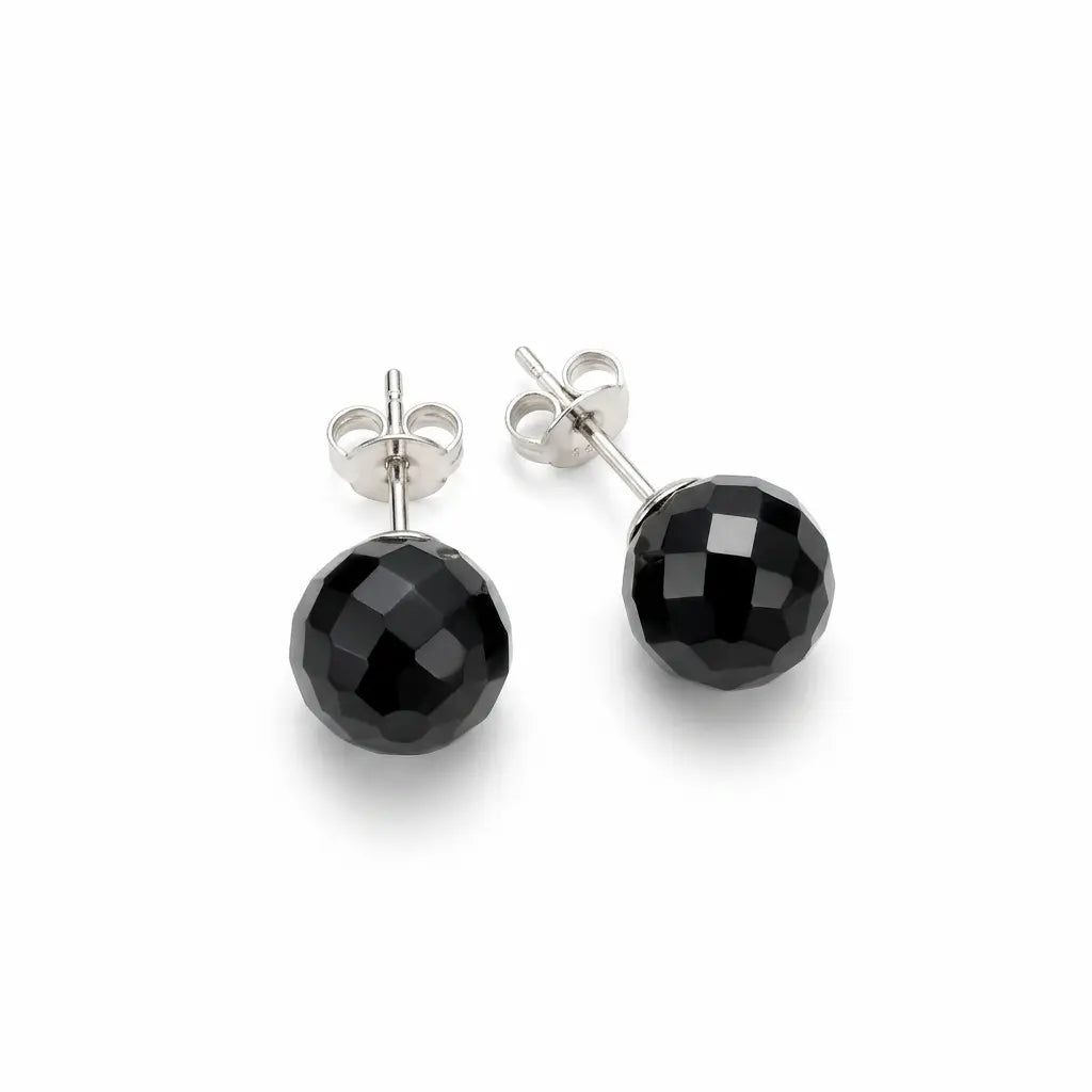 Close-up of faceted black 08 mm spherical earrings showing their geometric surfaces, silver posts and butterfly backs.