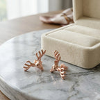 18K rose gold plated 925 sterling silver antler stud earrings displayed on a marble surface in Dubai.