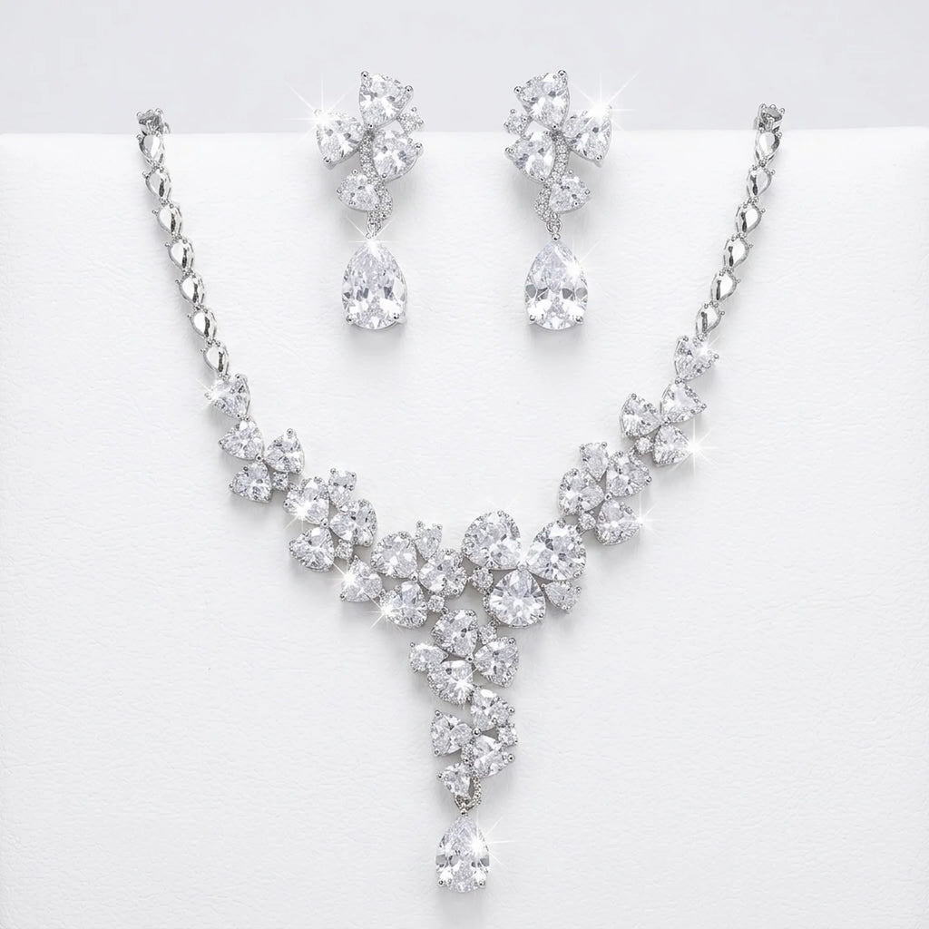 Floral cluster Y-drop necklace and earring set in rhodium-plated cubic zirconia, displayed on a white stand in Dubai.