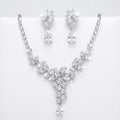 Floral cluster Y-drop necklace and earring set in rhodium-plated cubic zirconia, displayed on a white stand in Dubai.
