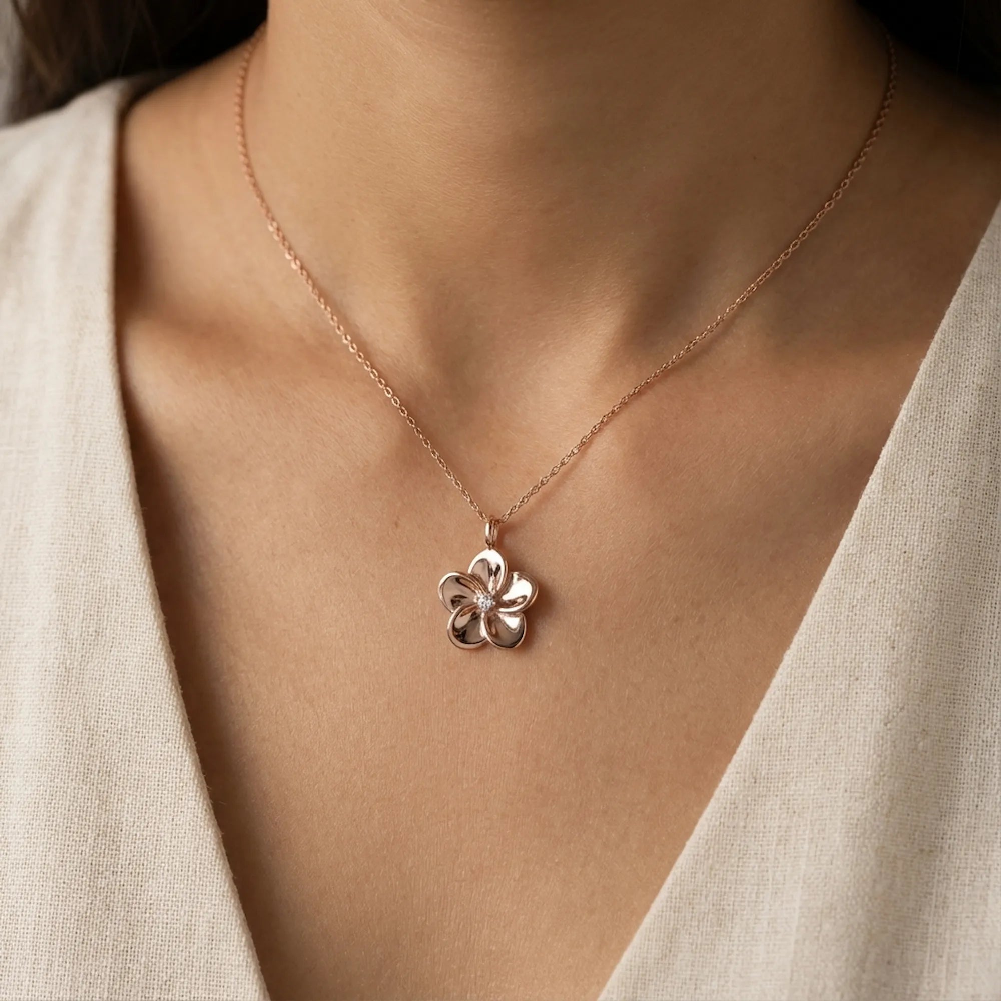 Rose gold flower pendant necklace worn at collarbone on model in cream top — 925 sterling silver
