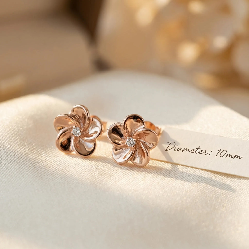 Pair of rose gold flower stud earrings on cream linen with 10 mm diameter measurement detail