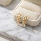 Gold four-leaf clover huggie hoop earrings with cubic zirconia, Luna Dura Dubai.